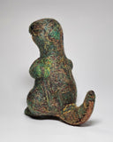 A handmade felted wool dinosaur toy with a textured, multi-colored body in shades of green, gold, and brown, standing against a neutral light gray background.