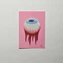 A vertical art work featuring a surreal illustration of a dripping eyeball on a solid pink background, displayed against a neutral light gray wall.