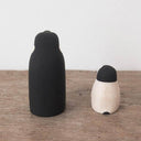 2 small wooden figurines of penguins, one is a parent and the other is a child.