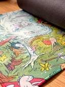 Colorful illustration on a neoprene desk mat of a dragon and fairies in a fantasy landscape with stars and flowers.