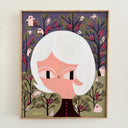 A framed folk art style painting of a woman with short white hair, set against a whimsical forest background with pink creatures and red birds. The painting is housed in a light wood frame and displayed on a neutral wall.