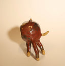Ceramic sculpture of a brown cat, with 6 very long, thin legs and a giant open mouth, which comprises most of its face and all of its body. It has a tiny tongue and small fangs. The cat has small dot eyes and pointed ears.
