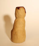 Ceramic sculpture of a tall brown cat, sitting and looking forward with simplistic eyes and a nose. Its head is cut open in a cross section, with blood spilling out.