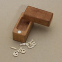 Wooden box with tiny wooden die cut items of weapons, and skulls. 