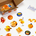 Glittery display of stickers themed around oranges, the fruit itself and orange adjacent foods.