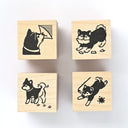 Four wooden rubber stamps with black dog illustrations on a white background