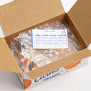 Open cardboard box with plastic-wrapped items and an invoice on a white background