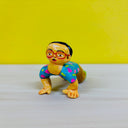 Clay sculpture of a yellow man with glasses and a surprised expression. He is kneeling on the ground with his hands touching the floor and his knees are on the ground as well.