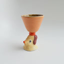 Ceramic orangish pink cup with a brown floppy eared dog as a handle.