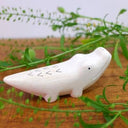 Wooden figurine of a crocodile with a cute, smiling face.