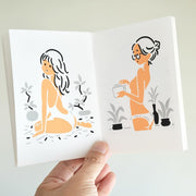 Illustrated book spread with two women, one sitting and one standing, holding a book. Both are dressed scantily and looking back over her shoulder.