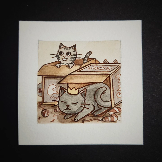 Illustration of a cat with a small crown in a cardboard box fort, with a kitty playing happily nearby.