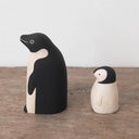 2 small wooden figurines of penguins, one is a parent and the other is a child.