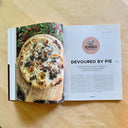 Open magazine spread featuring a photograph of a pizza with an accompanying article titled "Devoured by Pie"