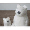 Two white, wooden polar bear figures with black noses and cute cartoon smiles.