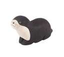 Wooden figurine of a black and white sea otter or seal.