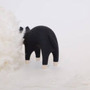 Wooden figurine of a black and natural wood color cat with an arched back.