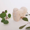 Wooden figurine of a fluffy chow chow dog, standing with its mouth open in a smile.