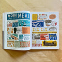 Open magazine spread with colorful illustrations on a wooden surface