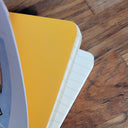 Notebook with yellow cover on a wooden surface