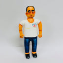 Clay sculpture of a man in a white t-shirt, jeans and black shirts. He has a tired expression, a 5 o'clock shadow and a receding hairline.