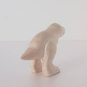 White wooden figure of a dinosaur.