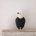 Black and white bird figurine on a wooden surface with a light gray background