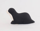 Side view of a black and white sea otter figurine.