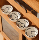 Set of 4 bowls with graphics of Snoopy, sitting or laying. They are with a brownish pink gift box set.
