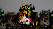 Black spray painted Big Boss Robot figures, with gold, white, red and green color accents. Their robot body features designs of paper cranes, as well as small leaf and flower iconography.