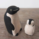2 small wooden figurines of penguins, one is a parent and the other is a child.