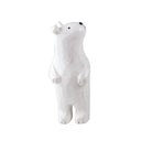 White wooden figure of a polar bear, standing up on its hind legs and smiling.