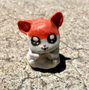 Small sculpture of an orange and white cartoon hamster - Hamtaro. 