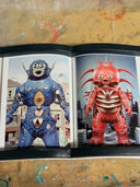 Open book showing two colorful monster illustrations on a textured surface.