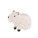 Small white wood figurine of a capybara, sitting with black color accents.