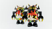 Black spray painted Big Boss Robot figures, with gold, white, red and green color accents. Their robot body features designs of paper cranes, as well as small leaf and flower iconography.