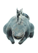 Ceramic sculpture of a large dark gray Godzilla character with a thicker, large body and a curled tail. It has gray glazed spikes along its back and has its mouth open wide, showing small sharp white teeth.