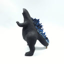 Black matte ceramic sculpture of a large Godzilla character, with many blue glazed spikes atop its back and a thick tail, standing with its mouth open. Its large tail rests on top of a small sitting dog. 