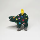 Needle felted wool sculpture of a dark green rounded body quadruped creature with an open mouth smile and small black eyes. Its body has colorful polkadots, like lights on a Christmas tree and a felted yellow star on top.