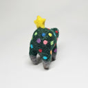 Needle felted wool sculpture of a dark green rounded body quadruped creature with an open mouth smile and small black eyes. Its body has colorful polkadots, like lights on a Christmas tree and a felted yellow star on top.