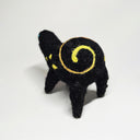 Felted sculpture of a black rounded body quadruped creature with a cute open mouth and bright blue dot eyes. It has a thread of red to orange to yellow ribbon spiraling across its body.