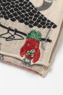 Embroidered fabric with a design of a red upside down demon, hanging off of a clothesline.