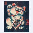 Risograph print, mostly dark blue with fluorescent orange coloring of a white beckoning maneki cat, with one paw raised and the other rested over a oval shaped token. It has a wide smile with 2 sharp teeth.