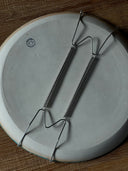 Back view of ceramic plate to show wire apparatus that allows the piece to be hung on the wall.