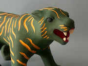 Matte finished ceramic sculpture of a green tiger with orange stripes, it is in a prowling stance with its mouth in a slightly growl.