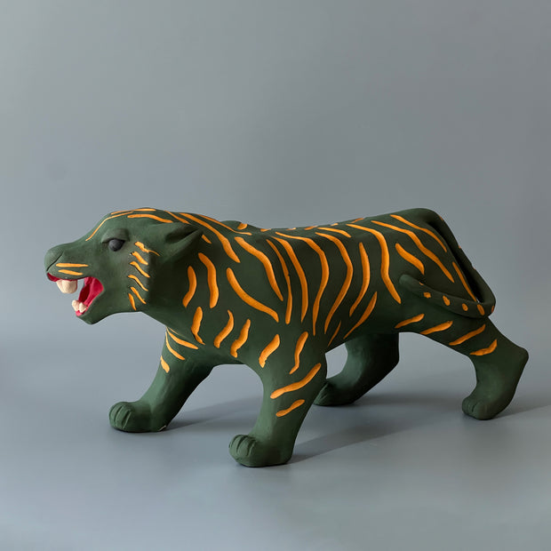Matte finished ceramic sculpture of a green tiger with orange stripes, it is in a prowling stance with its mouth in a slightly growl.