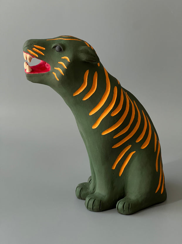 Matte finish ceramic sculpture of a green tiger with orange stripes, sitting on its hindlegs and with an open mouth smile