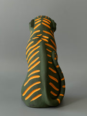 Matte finish ceramic sculpture of a green tiger with orange stripes, sitting on its hindlegs and with an open mouth smile