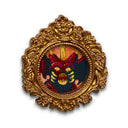 Miniature painting of a kaiju monster in a gold frame on a white background
