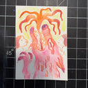 A small square art print or card featuring a colorful abstract illustration with orange and red wolf creature, placed on a black gridded cutting mat.